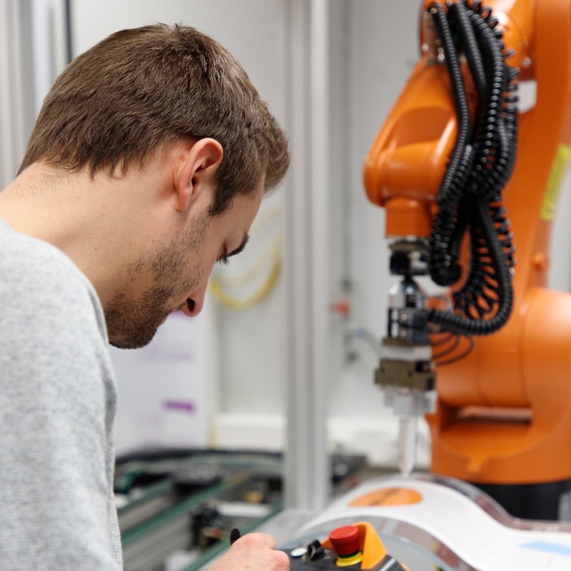 Schüler arbeitet am Kuka-Roboter in der Fertigungstechnik
